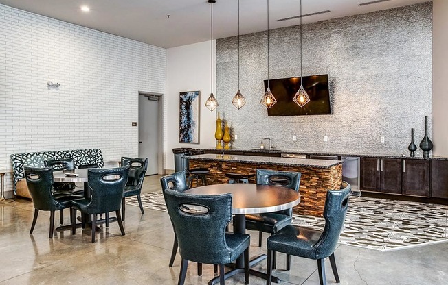 a dining area with a table and chairs and a bar in the background