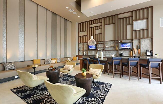 the lobby of a hotel with a bar and chairs