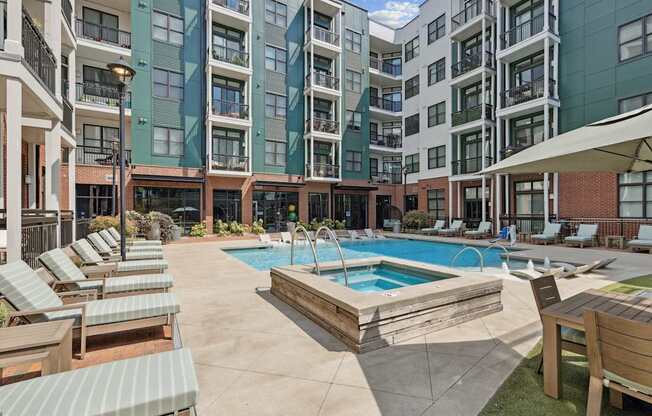 A large outdoor pool area with sun loungers and a wooden deck.