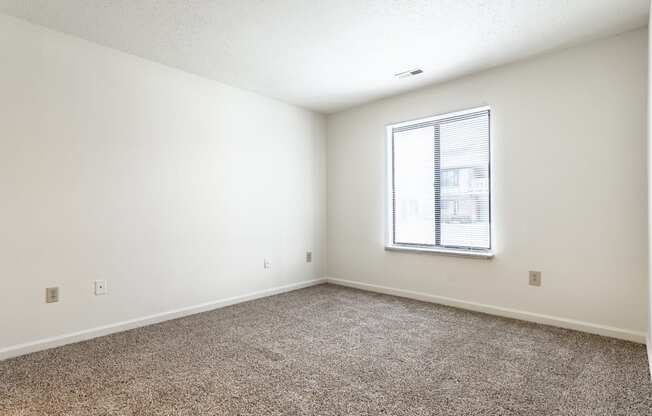 an empty room with carpet and a window at Pheasant Run in Lafayette, IN 47909