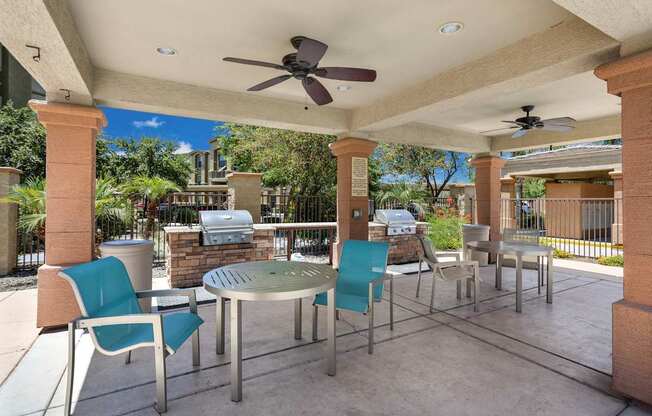 A patio with a table and chairs under a roof.