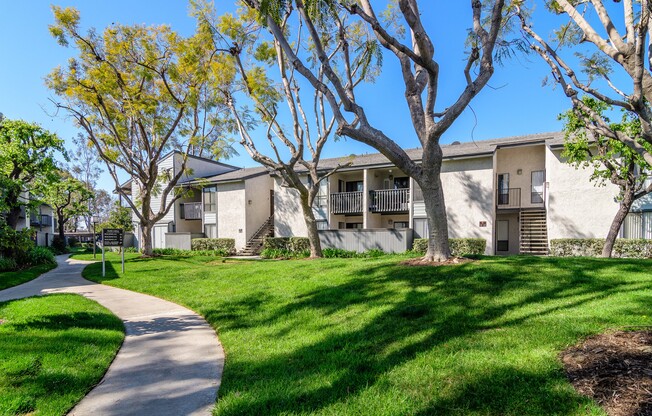 A building with a white facade and a green lawn in front.
