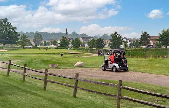 A golf cart is driving down a path in a grassy area.