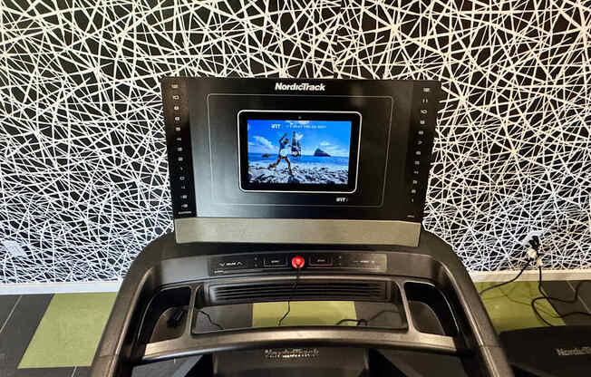 A car dashboard with a screen displaying a video of a person on a rocky terrain.