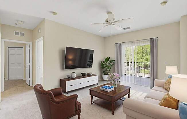 A living room with a brown leather chair, a white couch, a wooden coffee table, and a flat screen TV mounted on the wall.