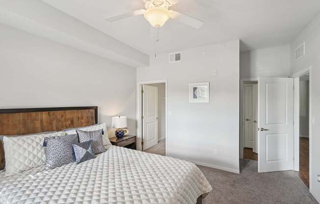 A bedroom with a large bed and a ceiling fan.