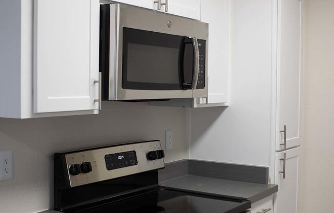A microwave is built into a cabinet in a kitchen.