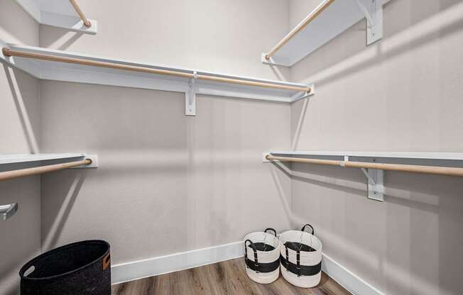 A room with a white wall and a black trash can.