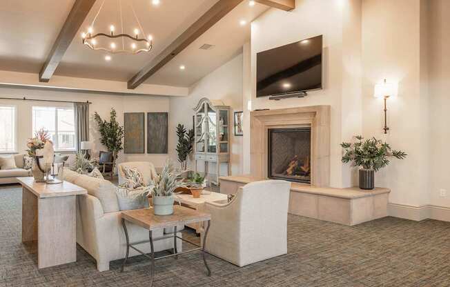 A living room with a fireplace and a television mounted above it.