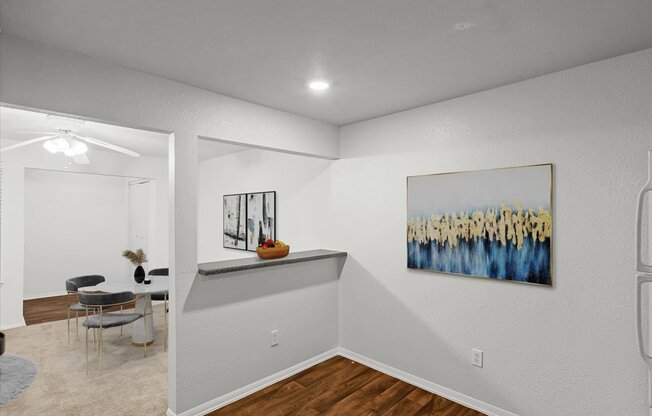 an empty room with a dining room table and a painting on the wallat Millcreek Woods Apartments, Olathe