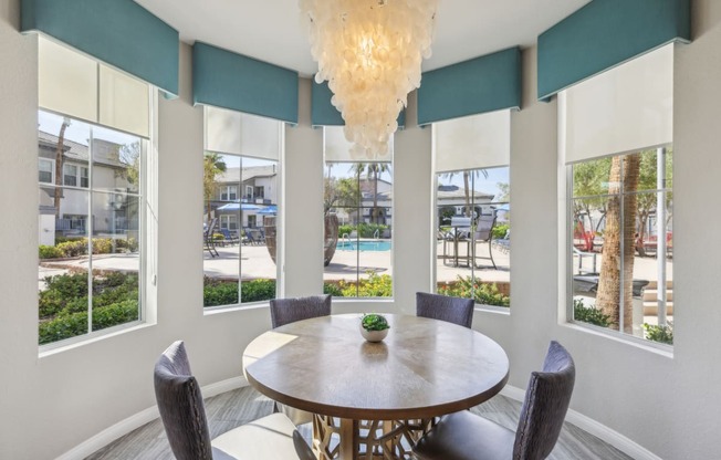 a dining room with a table and chairs and windows