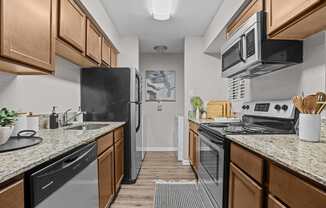 A kitchen with black appliances and wooden cabinets.