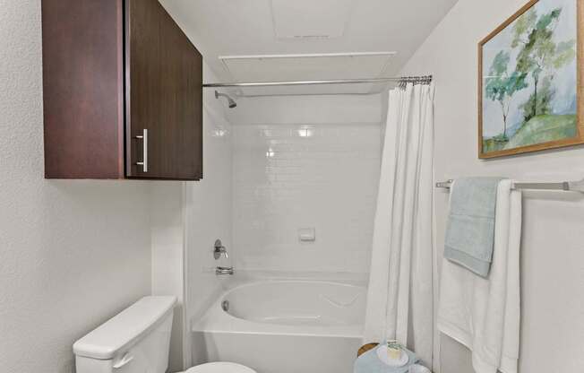 A bathroom with a toilet, sink, and bathtub.