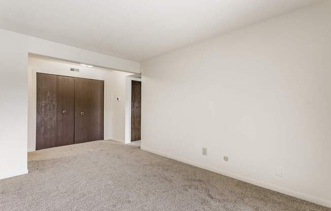 A room with a carpeted floor and a brown door