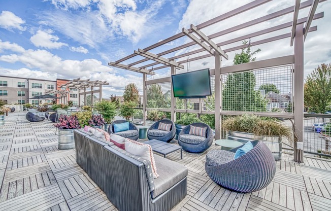 Outdoor patio with couches and a tv at Platform 14, Hillsboro, OR