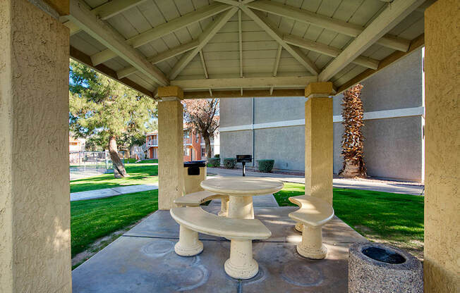 A white pedestal sink is in the middle of a concrete patio.