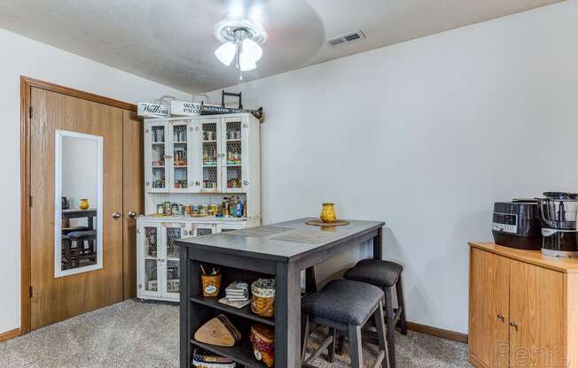 a breakfast bar with stools in the corner of a living room with a kitchen