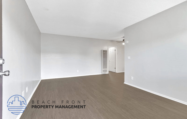 an empty living room with white walls and wood flooring