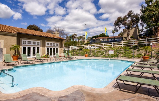 Carlsbad Apartments for Rent-Santa Fe Ranch Gated Pool With Lounge Chairs And Surrounding Brown Stone