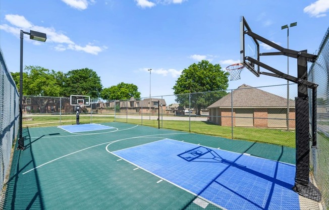 A basketball court with a blue and green surface and a basketball hoop.