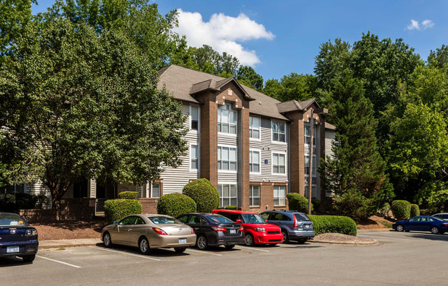 an apartment building with cars parked in a parking lot