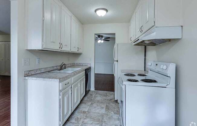 A kitchen with white appliances and cabinets.