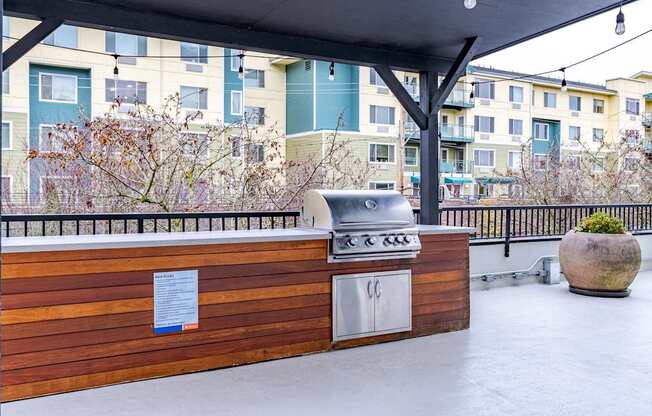 A BBQ grill is on a wooden deck with a sign on it.