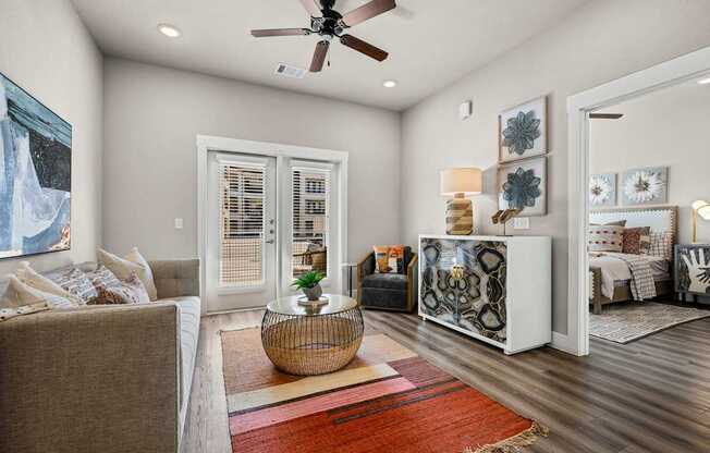 A living room with a brown couch and a red rug.