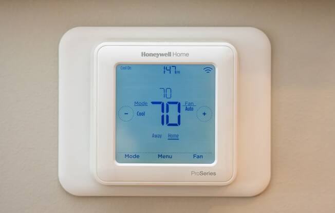 a thermostat on a hotel room wall