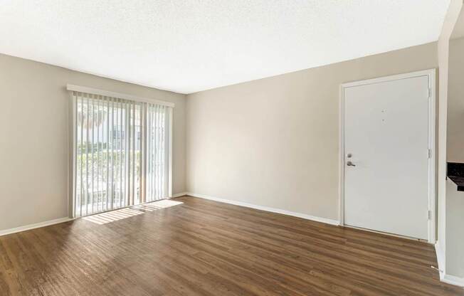 A room with wooden flooring and a sliding glass door.