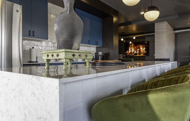 A grey vase sits on a green and white counter.