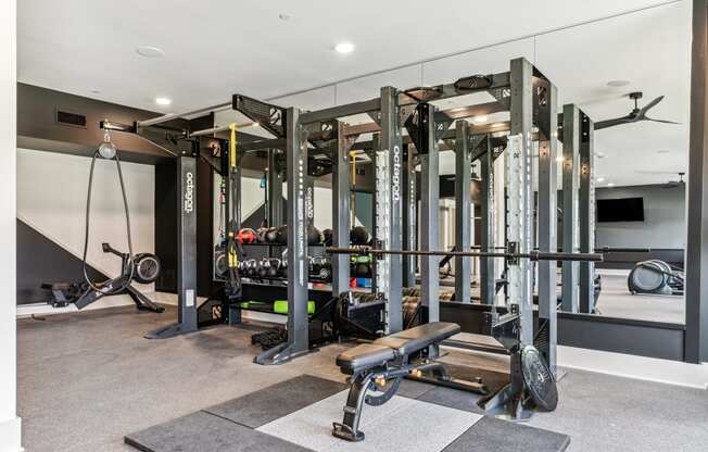 a home gym with weights machines and a tv