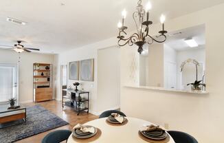 a living room with a dining room table and a chandelier