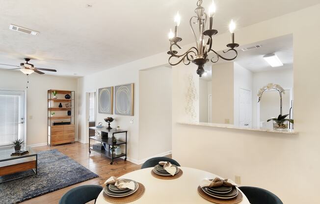 a living room with a dining room table and a chandelier