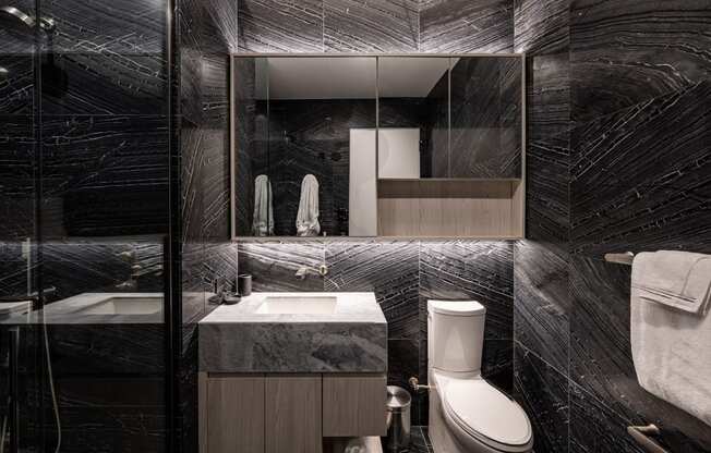 a bathroom with black and white tiles and a large mirror