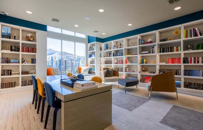 A room with a desk, chairs, and bookshelves.