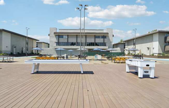 a white bench on a wooden deck in front of a building