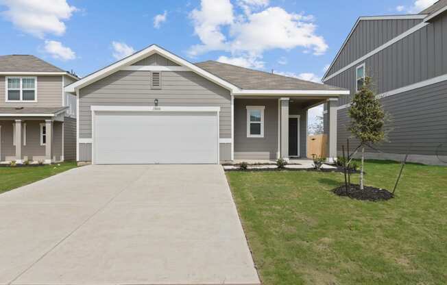 a gray house with a white garage door at Beacon at Presidential Heights, Manor, 78653