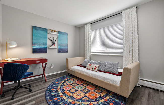 a living room with a couch and a desk with a chair