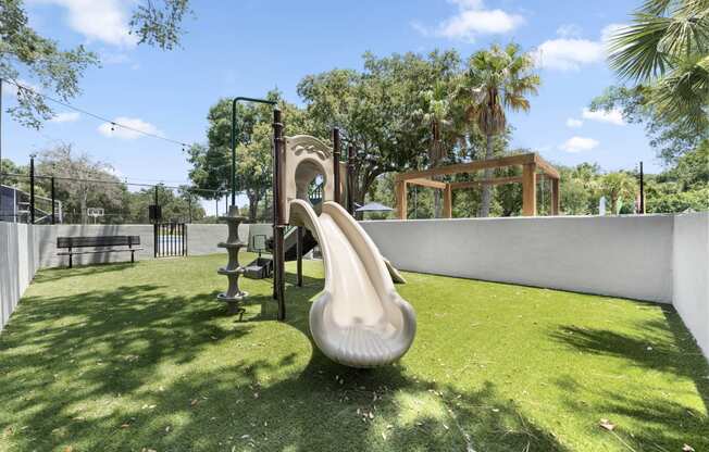 a playground with a slide and a swing set in a backyard