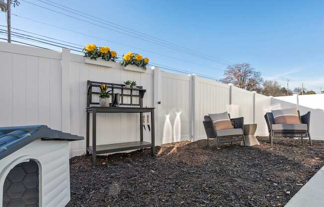 a fenced backyard with decor, a dog house, and flowers on the fence at Sanctuary at Indian Creek Rental Homes in Madison near Huntsville