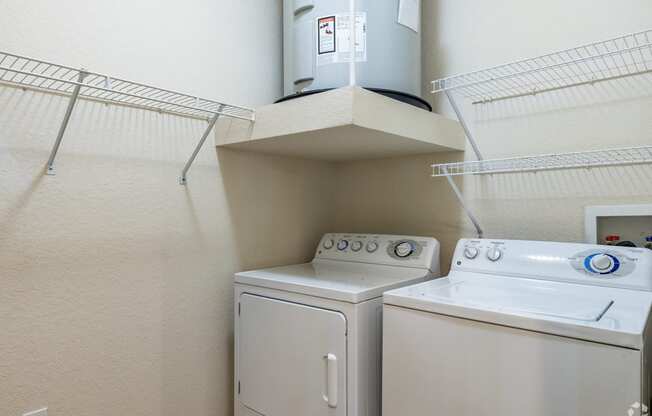 a washer and dryer in a room with a shelf above it and a