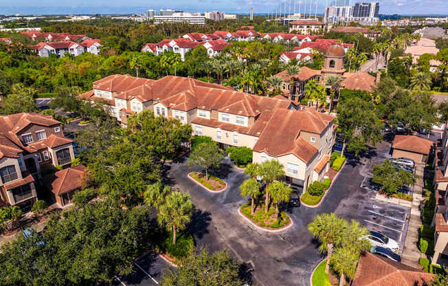 Aerial of apartment buildings with terracotta roofs and parking areas