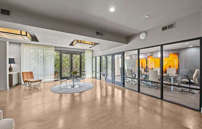 a large living room with glass windows and a table and chairs