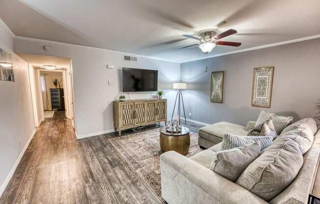 a living room with a couch and a ceiling fan