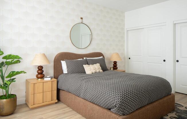 A calming bedroom retreat with textured wallpaper, warm wood tones, and layered neutrals for effortless comfort.