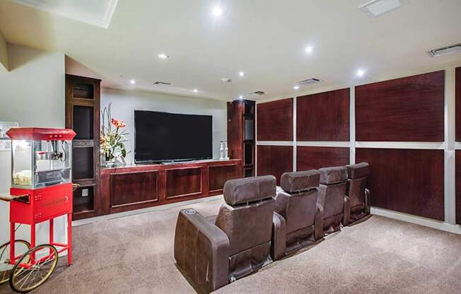 a living room with leather chairs and a television