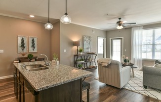 a kitchen with an island and a living room in the background at Meridian Park in Collierville, TN 38017