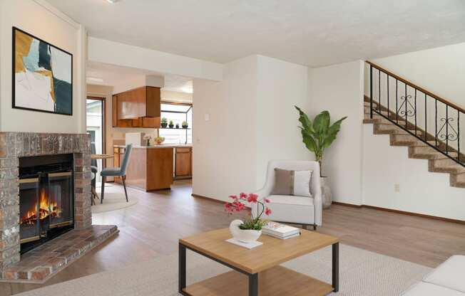 Living room with brick fireplace to the left, opening to the dining and kitchen area, stairs to upstairs on the right. at Hawks Prairie, Olympia, WA