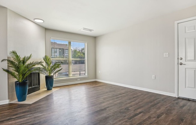 an empty living room with a window and a door